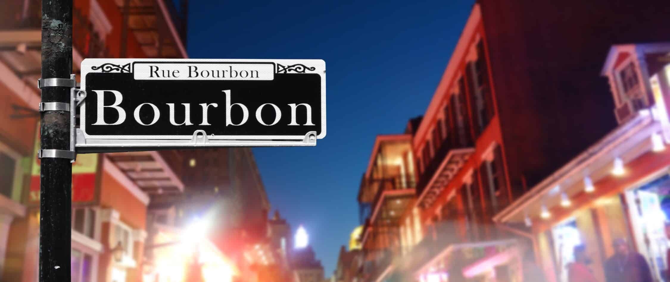 Bourbon Street sign with bars in the background.