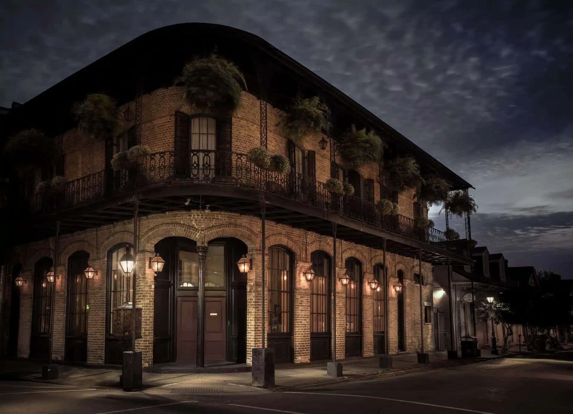 A spooky image of Muriel's Jackson Square, a legendary New Orleans restaurant, illuminated by French Quarter street lamps.