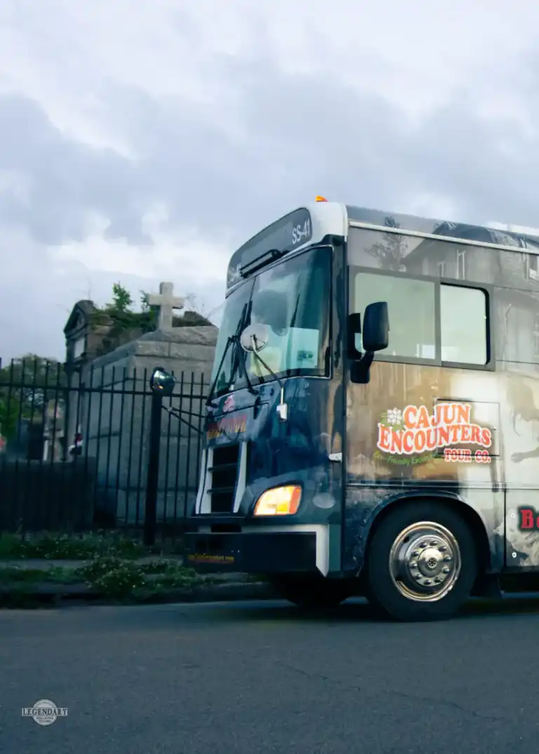 New Orleans ghost bus tour vehicle parked near a cemetery